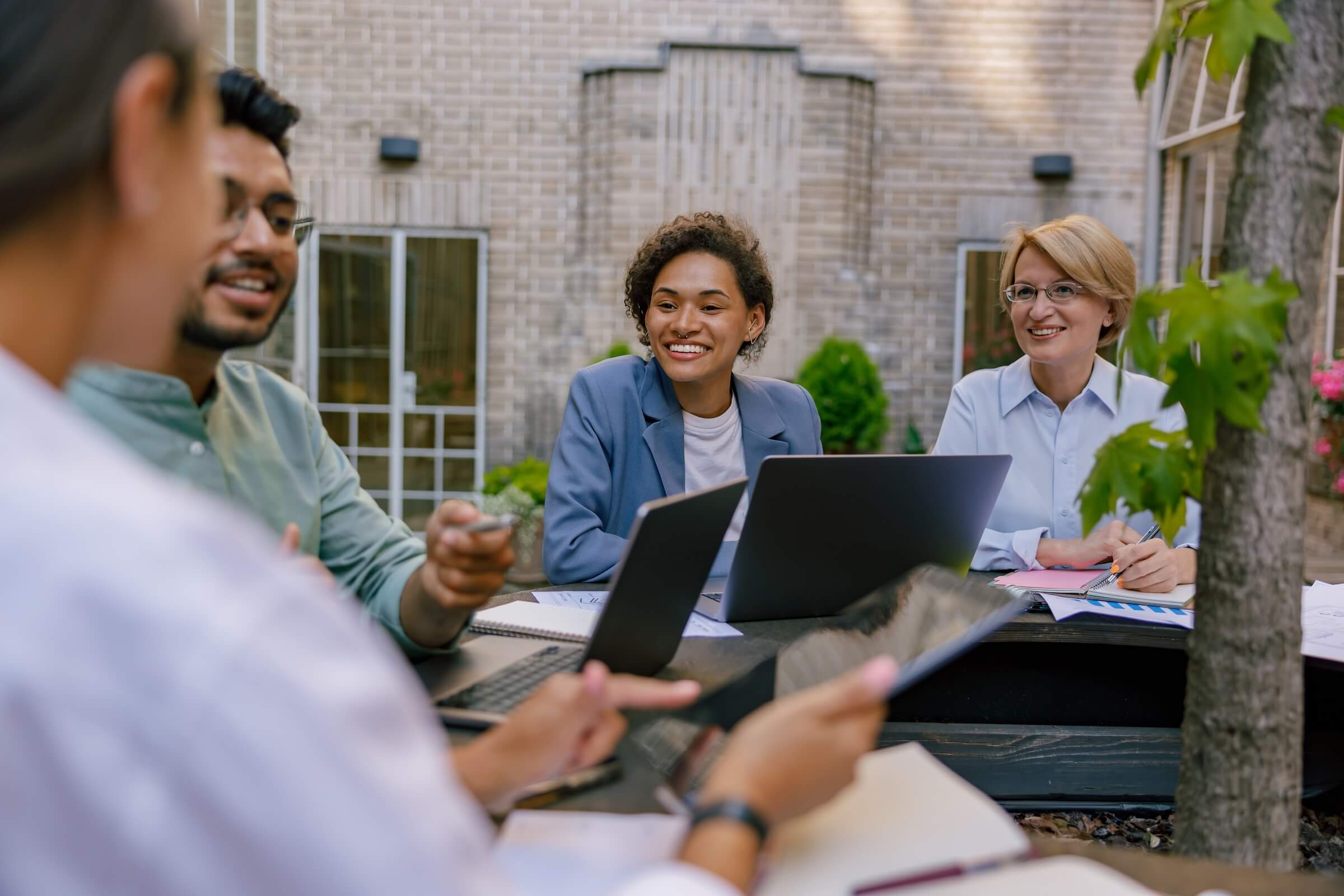 A diverse group of men and women having a business meeting outdoors