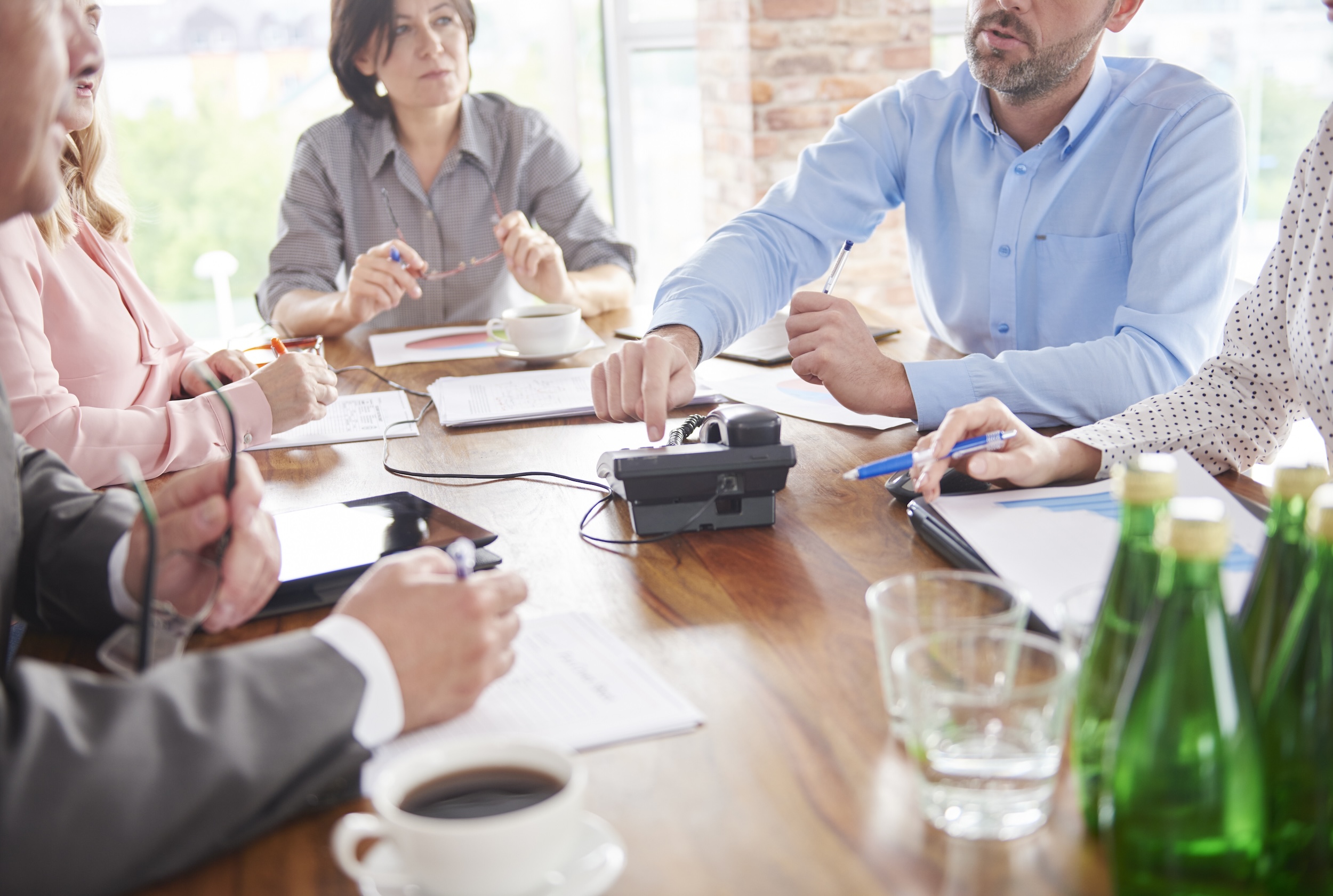 Several people sitting around a table having a business meeting. 