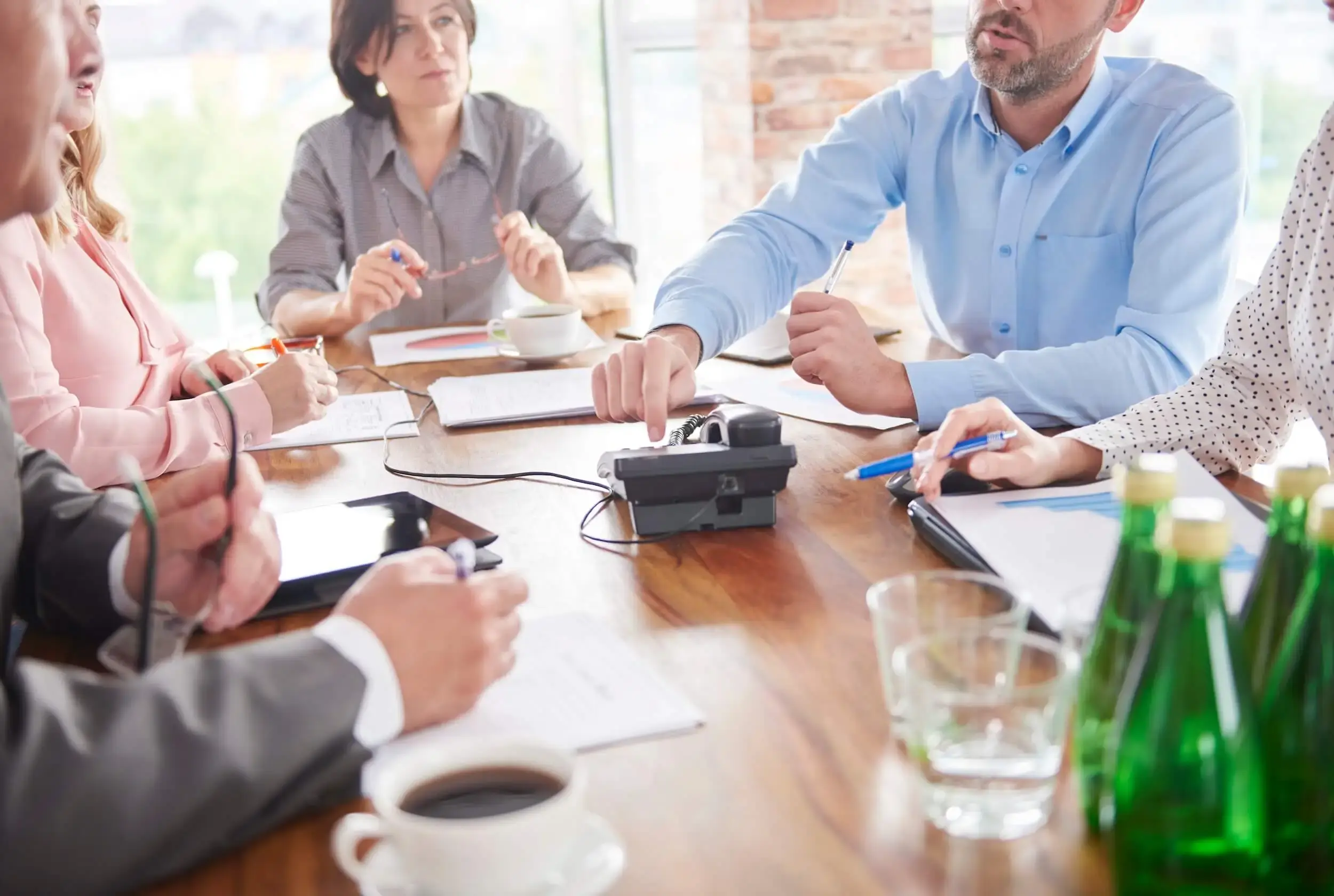 Several people sitting around a table having a business meeting. 