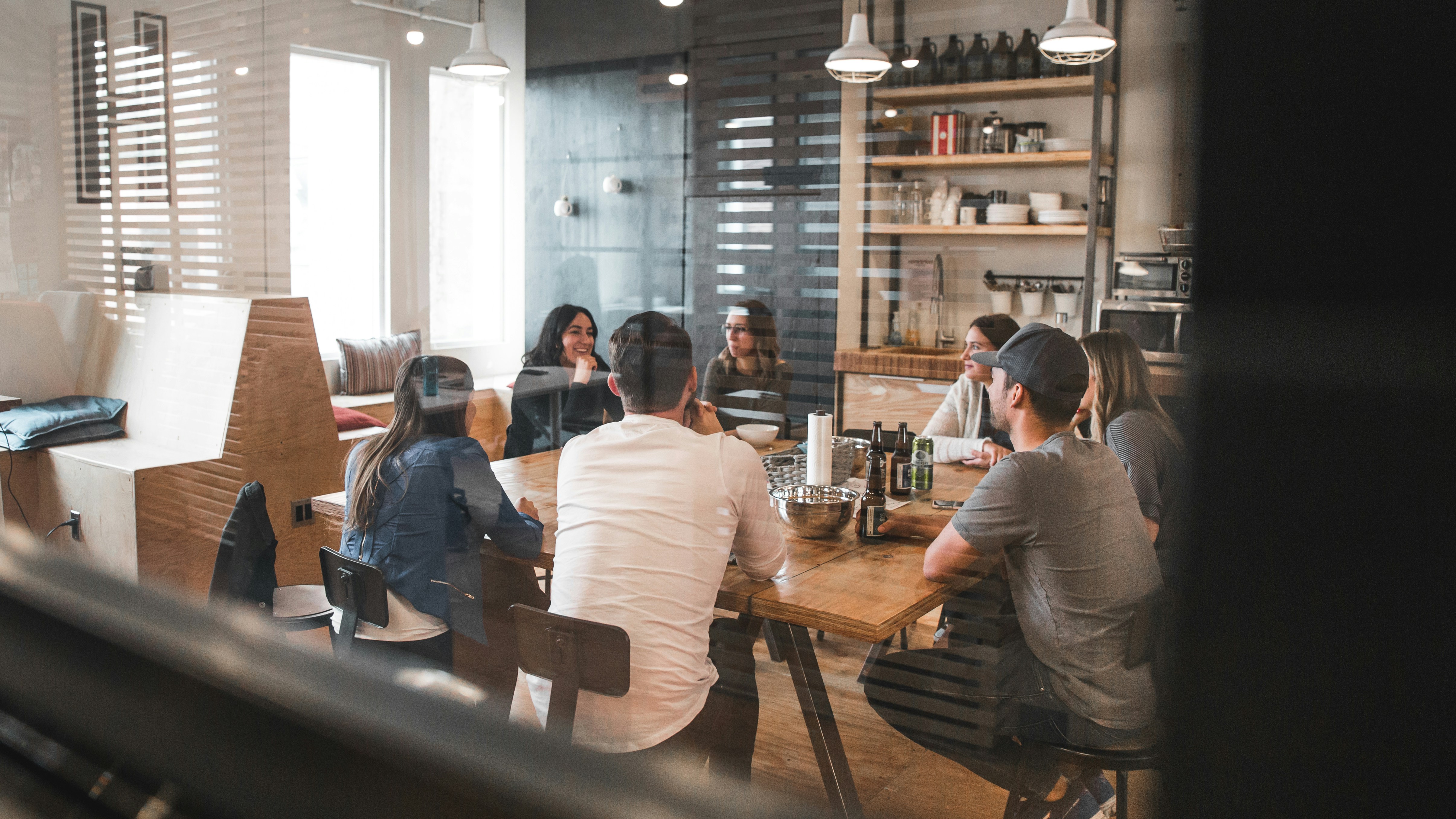 People sitting around a large table at work during a meeting. 